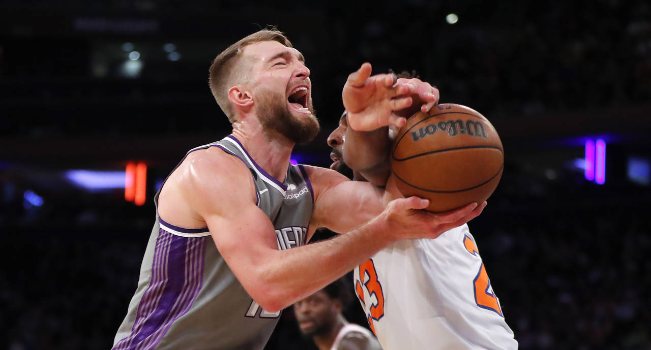 Sacramento Kings forward Domantas Sabonis is fouled by New York Knicks center Mitchell Robinson (23...