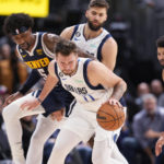 
              Dallas Mavericks guard Luka Doncic, front, protects the ball as Denver Nuggets guard Kentavious Caldwell-Pope, left, defends during the second half of an NBA basketball game Tuesday, Dec. 6, 2022, in Denver. (AP Photo/David Zalubowski)
            