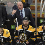 
              Boston Bruin coach Jim Montgomery speaks to players from the bench during the first period of the team's NHL hockey game against the Philadelphia Flyers, Thursday, Nov. 17, 2022, in Boston. (AP Photo/Steven Senne)
            
