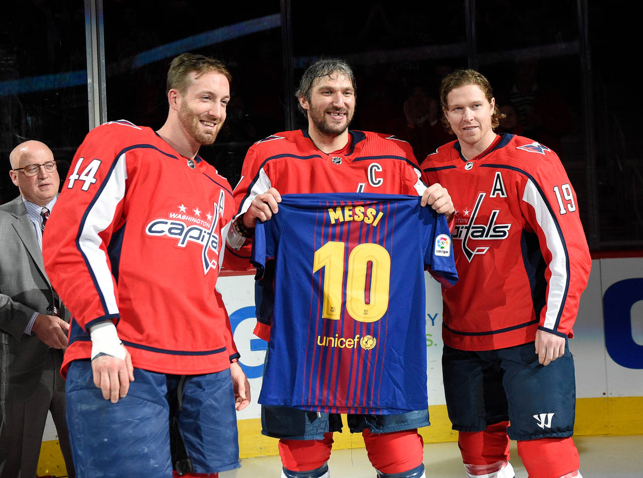 FILE - Washington Capitals left wing Alex Ovechkin, center, of Russia, poses with a Messi soccer je...