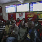 
              Customers watch screens in a sports betting shop in the low-income Kibera neighborhood of the capital Nairobi, Kenya, Monday, Dec. 5, 2022. Although sports betting is a global phenomenon and a legitimate business in many countries, the stakes are high on the continent of 1.3 billion people because of lax or non-existent regulation, poverty and widespread unemployment. (AP Photo/Brian Inganga)
            