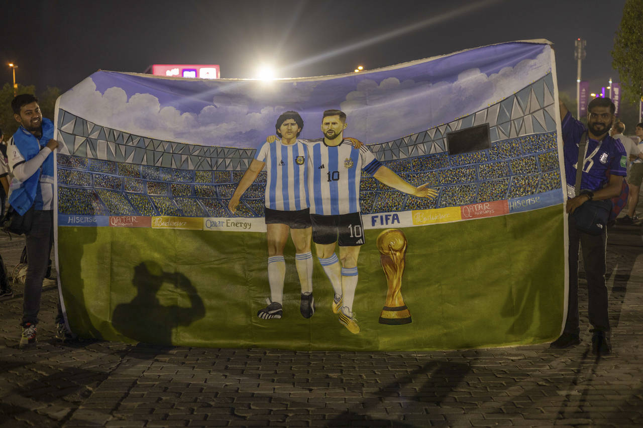 Mohid Data and Aayush Verma from India show a huge painting of their heroes, Lionel Messi and Diego...