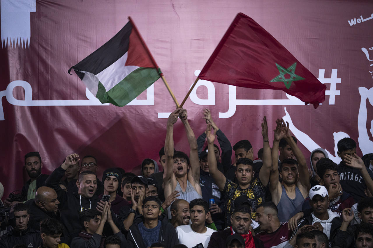 FILE - Palestinians wave Moroccan and their national flags as they watch a live broadcast of the Wo...