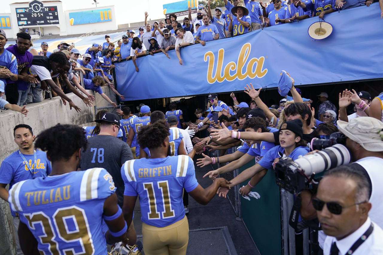FILE - UCLA football players greet fans as they leave the field after a 42-32 win over Utah in an N...