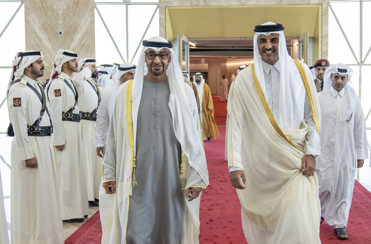 In this photo released by Qatar Amiri Diwan, Qatari Emir Sheikh Tamim bin Hamad Al-Thani, right, gr...