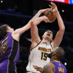 
              Los Angeles Lakers guard Austin Reaves (15) stops a shot by Denver Nuggets center Nikola Jokic (15) during the second half of an NBA basketball game in Los Angeles, Friday, Dec. 16, 2022. (AP Photo/Ashley Landis)
            