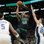 
              Boston Celtics center Al Horford (42) drives to the basket between Orlando Magic forwards Paolo Banchero (5) and Franz Wagner (22) during the first half of an NBA basketball game, Sunday, Dec. 18, 2022, in Boston. (AP Photo/Mary Schwalm)
            