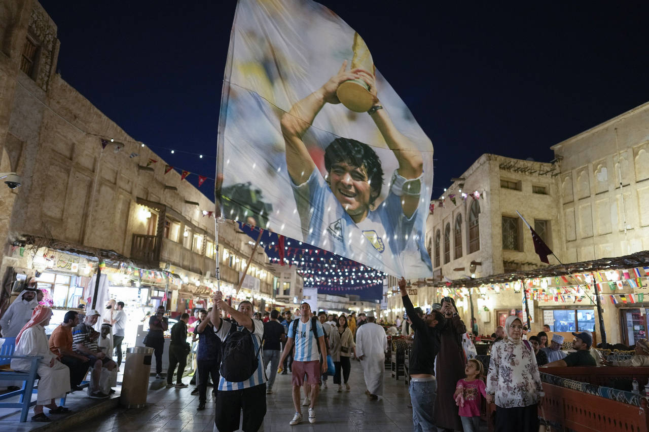 A fan of Argentina waves a flag with the image of late Argentinean soccer star Diego Maradona in So...