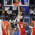 
              Memphis Grizzlies forward Santi Aldama, center top, goes up to dunk against Atlanta Hawks guard Trent Forrest (2) in the first half of an NBA basketball game Monday, Dec. 12, 2022, in Memphis, Tenn. (AP Photo/Brandon Dill)
            