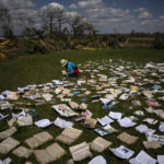 
              A teacher lays out rain-soaked books to air dry on the grounds of a school that was heavily damaged by Hurricane Ian in La Coloma, in the province of Pinar del Rio, Cuba, on Oct. 5, 2022. (AP Photo/Ramon Espinosa)
            