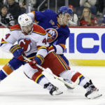 
              New Jersey Devils left wing Miles Wood (44) is tripped by New York Islanders defenseman Ryan Pulock during the first period of an NHL hockey game Friday, Dec. 9, 2022, in Newark, N.J. (AP Photo/Adam Hunger)
            