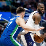
              Los Angeles Lakers forward LeBron James instructs his teammates on the floor as Dallas Mavericks guard Luka Doncic defends him in the first half of an NBA basketball game in Dallas, Sunday, Dec. 25, 2022. (AP Photo/Emil T. Lippe)
            