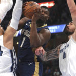 
              New Orleans Pelicans forward Zion Williamson (1) shoots while defended by Memphis Grizzlies guard Dillon Brooks (24) and center Steven Adams (4) during the first half of an NBA basketball game Saturday, Dec. 31, 2022, in Memphis, Tenn. (AP Photo/Nikki Boertman)
            