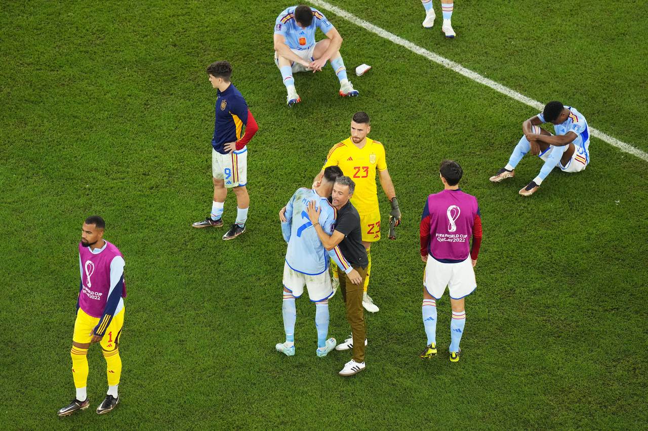 Spain's head coach Luis Enrique, centre right bottom, hugs Spain's Alvaro Morata after the World Cu...