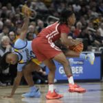 
              Marquette's Sean Jones fouls Wisconsin's Kamari McGee during the second half of an NCAA college basketball game Saturday, Dec. 3, 2022, in Milwaukee. Wisconsin won 80-77 in overtime. (AP Photo/Morry Gash)
            