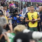 
              Photographers crowd around as Portugal's Cristiano Ronaldo arrives to take his seat on the bench prior the start of the World Cup round of 16 soccer match between Portugal and Switzerland, at the Lusail Stadium in Lusail, Qatar, on Tuesday, Dec. 6, 2022. (AP Photo/Pavel Golovkin)
            