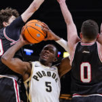 
              Purdue guard Brandon Newman (5) shoots between Davidson guard Achile Spadone (20) and guard Foster Loyer (0) in the first half of an NCAA college basketball game in Indianapolis, Saturday, Dec. 17, 2022. (AP Photo/Michael Conroy)
            
