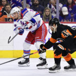 
              New York Rangers' Jonny Brodzinski, left, takes a shot past the defense of Philadelphia Flyers' Cam York during the third period of an NHL hockey game, Saturday, Dec. 17, 2022, in Philadelphia. (AP Photo/Derik Hamilton)
            