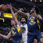 
              Indiana Pacers guard T.J. McConnell (9) and forward Oshae Brissett (12) go up for a rebound with Golden State Warriors forward Anthony Lamb (40) during the first half of an NBA basketball game in Indianapolis, Wednesday, Dec. 14, 2022. (AP Photo/Michael Conroy)
            