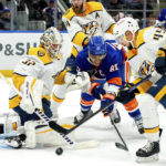 
              New York Islanders left wing Anders Lee (27) and Nashville Predators defenseman Alexandre Carrier (45) fight for the puck as Predators goaltender Kevin Lankinen (32) guards the goal during the second period of an NHL hockey game, Friday, Dec. 2, 2022, in Elmont, N.Y. (AP Photo/Julia Nikhinson)
            