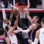 
              Chicago Bulls' Zach LaVine shorts between Washington Wizards' Daniel Gafford, left, and Kristaps Porzingis during the second half of an NBA basketball game Wednesday, Dec. 7, 2022, in Chicago. The Bulls won 115-111. (AP Photo/Charles Rex Arbogast)
            