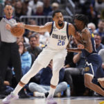 
              Dallas Mavericks guard Spencer Dinwiddie, left, is defended by Denver Nuggets guard Bones Hyland during the second half of an NBA basketball game Tuesday, Dec. 6, 2022, in Denver. (AP Photo/David Zalubowski)
            