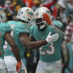 
              Miami Dolphins running back Jeff Wilson Jr. (23), celebrates with teammate Miami Dolphins running back Raheem Mostert (31) after scoring a touchdown during the first half of an NFL football game, Sunday, Dec. 25, 2022, in Miami Gardens, Fla. (AP Photo/Jim Rassol)
            