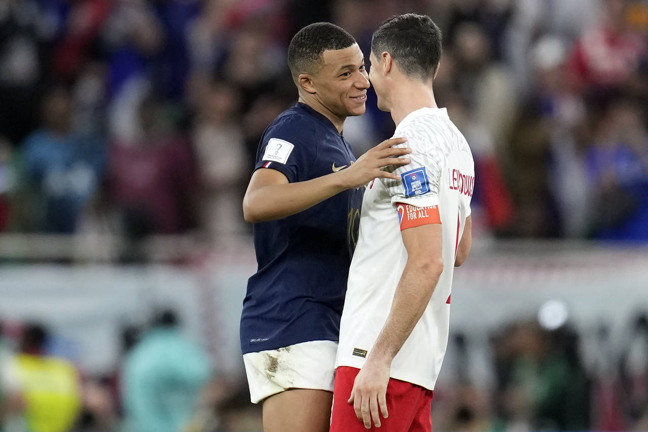 France’s Kylian Mbappe, left, and Poland's Robert Lewandowski talk after the World Cup round of 1...