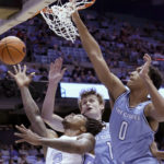 
              North Carolina guard Caleb Love (2) drives in against Citadel forwards Stephen Clark (1) and forward Jackson Price (0) during the first half of an NCAA college basketball game Tuesday, Dec. 13, 2022, in Chapel Hill, N.C. (AP Photo/Chris Seward)
            