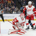 
              Detroit Red Wings' Ville Husso, left, makes a save as teammate Ben Chiarot, right, and Columbus Blue Jackets' Boone Jenner look for a rebound during the second period of an NHL hockey game on Sunday, Dec. 4, 2022, in Columbus, Ohio. (AP Photo/Jay LaPrete)
            