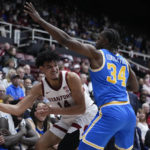 
              Stanford forward Spencer Jones (14) passes the ball while defended by UCLA guard David Singleton (34) during the first half of an NCAA college basketball game in Stanford, Calif., Thursday, Dec. 1, 2022. (AP Photo/Godofredo A. Vásquez)
            