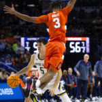 
              Syracuse's Judah Mintz (3) jumps up to defend Notre Dame's Cormac Ryan (5) during the second half of an NCAA college basketball game on Saturday, Dec. 3, 2022 in South Bend, Ind. (AP Photo/Michael Caterina)
            