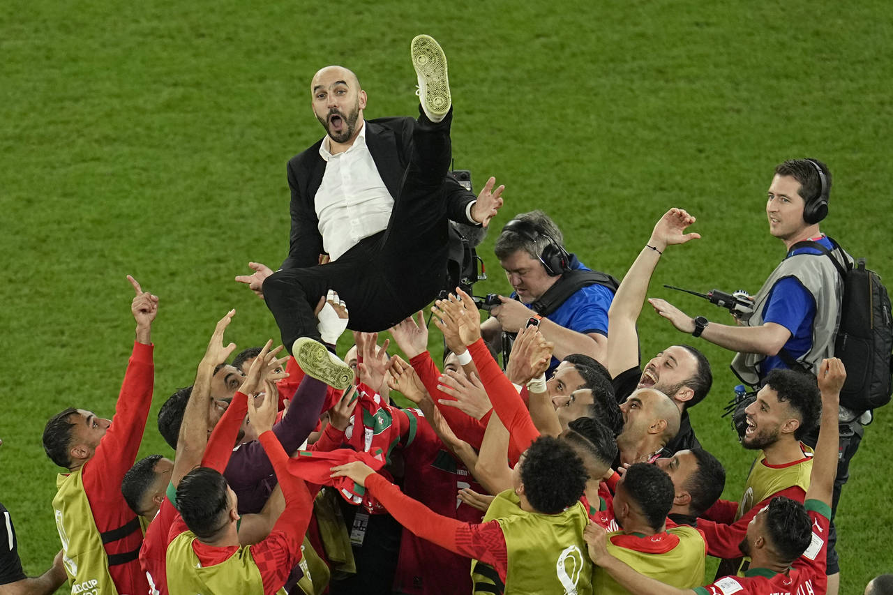 Morocco's head coach Walid Regragui is thrown in the air at the end of the World Cup round of 16 so...
