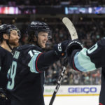 
              Seattle Kraken forward Jared McCann, center, celebrates with defenseman Adam Larsson, left, and forward Matty Beniers after scoring a goal against the St. Louis Blues during the second period of an NHL hockey game Tuesday, Dec. 20, 2022, in Seattle. (AP Photo/Stephen Brashear)
            