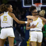 
              Notre Dame's Olivia Miles, center, hugs Dara Mabrey (1) as Natalija Marshall (15) smiles during the first half of an NCAA college basketball game against Connecticut on Sunday, Dec. 4, 2022, in South Bend, Ind. (AP Photo/Michael Caterina)
            