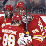 
              Calgary Flames goalie Jacob Markstron, right, and teammate Andrew Mangiapane (88) celebrate the team's 3-2 win over the Vancouver Canucks in an NHL hockey game Saturday, Dec. 31, 2022, in Calgary, Alberta. (Larry MacDougal/The Canadian Press via AP)
            