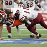 
              Bowling Green running back Ta'ron Keith, left, is tackled by New Mexico State defensive back Dylan Early (11) during the first half of the Quick Lane Bowl NCAA college football game, Monday, Dec. 26, 2022, in Detroit. (AP Photo/Al Goldis)
            