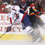 
              Washington Capitals' Alex Ovechkin, left, is hit by Calgary Flames' Andrew Mangiapane during the first period of an NHL hockey game Saturday, Dec. 3, 2022, in Calgary, Alberta. (Larry MacDougal/The Canadian Press via AP)
            