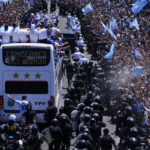 
              The Argentine soccer team shows off their World Cup trophy from a bus as they are welcomed home in Buenos Aires, Argentina, Tuesday, Dec. 20, 2022. The bus window reads in Spanish "World Champions." (AP Photo/Natacha Pisarenko)
            