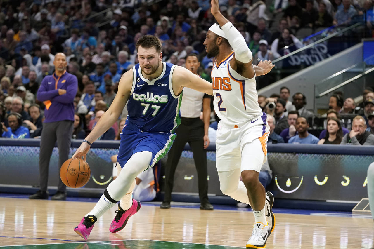 Dallas Mavericks guard Luka Doncic (77) drives against Phoenix Suns forward Josh Okogie (2) during ...