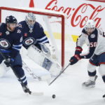 
              Winnipeg Jets goaltender David Rittich (33) watches as Columbus Blue Jackets' Eric Robinson (50) attempts to deflect a shot as Nate Schmidt (88) defends during the first period of an NHL hockey game Friday, Dec. 2, 2022, in Winnipeg, Manitoba. (John Woods/The Canadian Press via AP)
            