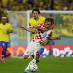 
              Brazil's Marquinhos, back, fights for the ball with Croatia's Luka Modric during the World Cup quarterfinal soccer match between Croatia and Brazil, at the Education City Stadium in Al Rayyan, Qatar, Friday, Dec. 9, 2022. (AP Photo/Frank Augstein)
            
