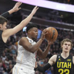 
              Miami Heat guard Kyle Lowry (7) passes the ball as Utah Jazz center Walker Kessler (24) and forward Lauri Markkanen (23) defend during the first half of an NBA basketball game Saturday, Dec. 31, 2022, in Salt Lake City. (AP Photo/George Frey)
            