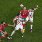 
              Morocco's Selim Amallah jumps for the ball between Croatia's Bruno Petkovic and Nikola Vlasic, right, during the World Cup third-place playoff soccer match between Croatia and Morocco at Khalifa International Stadium in Doha, Qatar, Saturday, Dec. 17, 2022. (AP Photo/Pavel Golovkin)
            