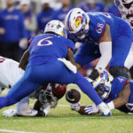 
              Kansas running back Devin Neal (4), offensive lineman Earl Bostick Jr. (68) and quarterback Jalon Daniels (6) and an Arkansas defender reach for the ball during the first half of Liberty Bowl NCAA college football game Wednesday, Dec. 28, 2022, in Memphis, Tenn. Arkansas recovered the ball. (AP Photo/Rogelio V. Solis)
            