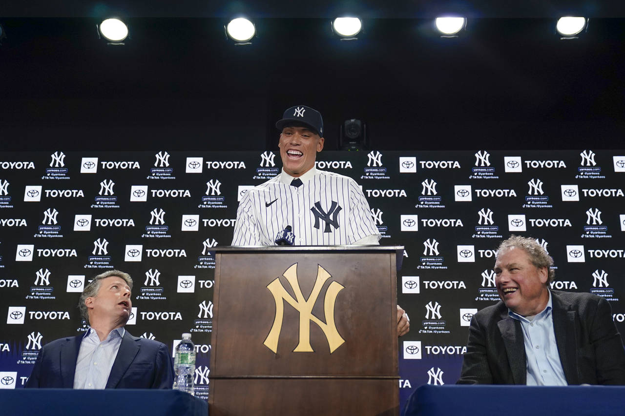 New York Yankees' Aaron Judge, center, speaks while owner Hal Steinbrenner, left, and president Ran...