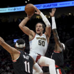 
              Denver Nuggets forward Aaron Gordon, center, drives to the basket as Portland Trail Blazers guard Josh Hart, left, and forward Jerami Grant defend during the first half of an NBA basketball game in Portland, Ore., Thursday, Dec. 8, 2022. (AP Photo/Steve Dykes)
            