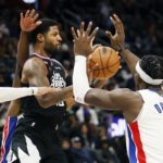 
              Los Angeles Clippers guard Paul George passes the ball against Detroit Pistons center Jalen Duren (0) during the first half of an NBA basketball game, Monday, Dec. 26, 2022, in Detroit. (AP Photo/Duane Burleson)
            