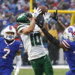 
              New York Jets wide receiver Braxton Berrios (10) reaches for the ball under pressure from Buffalo Bills cornerback Taron Johnson (7) and Bills cornerback Dane Jackson during the second half of an NFL football game, Sunday, Dec. 11, 2022, in Orchard Park, N.Y. (AP Photo/Jeffrey T. Barnes)
            