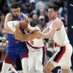 
              From left, Denver Nuggets forward Michael Porter Jr. fights for control of a loose ball with Portland Trail Blazers guard Josh Hart and forward Drew Eubanks in the first half of an NBA basketball game Friday, Dec. 23, 2022, in Denver. (AP Photo/David Zalubowski)
            